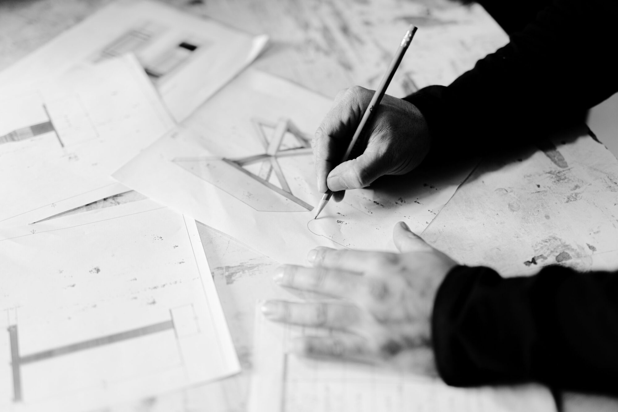 Close-up of a designer sketching custom furniture blueprints at South Loft, highlighting the creative process behind bespoke wood furniture for Texas homes and hospitality spaces.