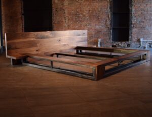 Custom platform bed frame with a solid wood headboard and industrial metal base by South Loft, designed for modern luxury interiors and handcrafted in Texas.