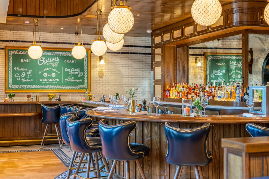 Counter height tables and bar stools placed near a window to optimize space and guest flow in a restaurant layout