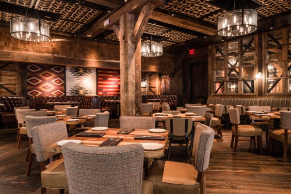 South Loft custom dining tables and chairs in a rustic restaurant with wooden beams and southwestern decor.