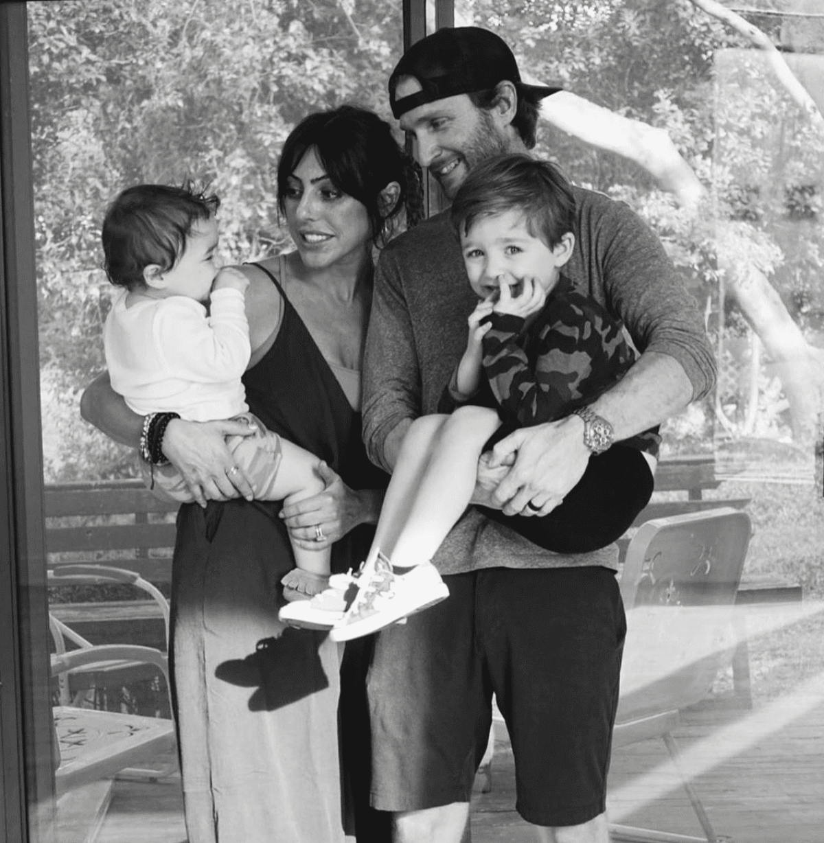 SouthLoft family standing together in a black-and-white photo, embracing their two young children.