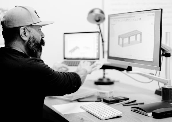 South Loft designer working on a computer, creating a 3D model of a custom table, showcasing the design process behind their bespoke furniture pieces.
