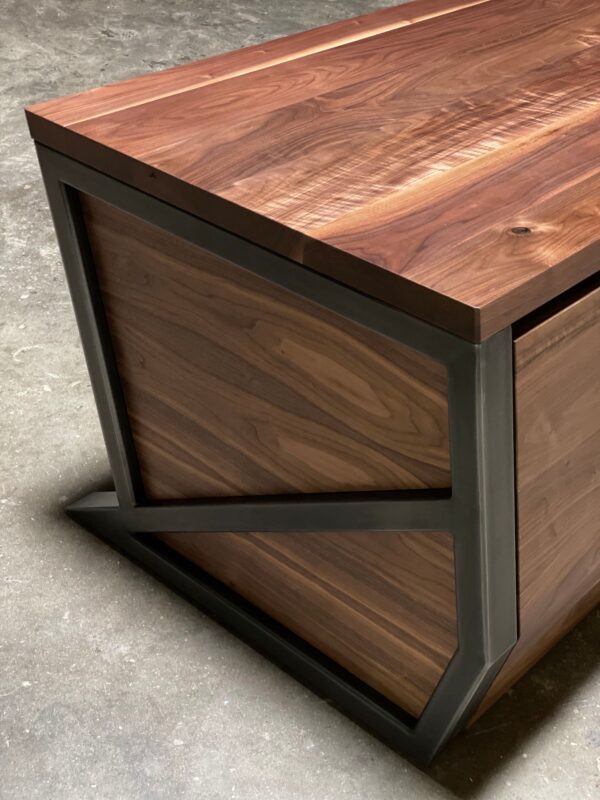 Close-up of South Loft executive desk with wood grain top and black angular metal frame.
