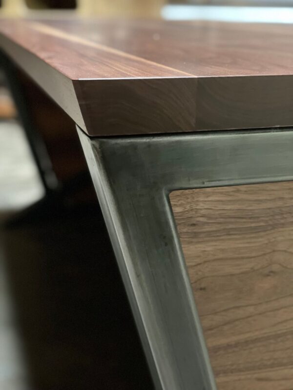 Close-up view of South Loft executive desk, featuring the seamless connection between the wood top and metal frame.