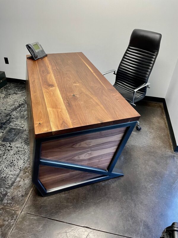 South Loft custom executive desk with a dark wood top and black metal base, paired with a black ergonomic office chair.