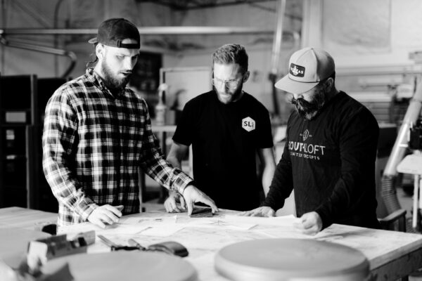 South Loft design team reviewing plans in a workshop.