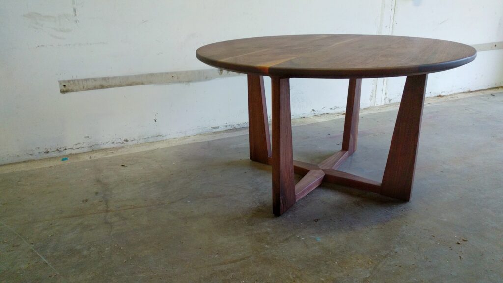 South Loft custom round wood table with a modern cross base design.