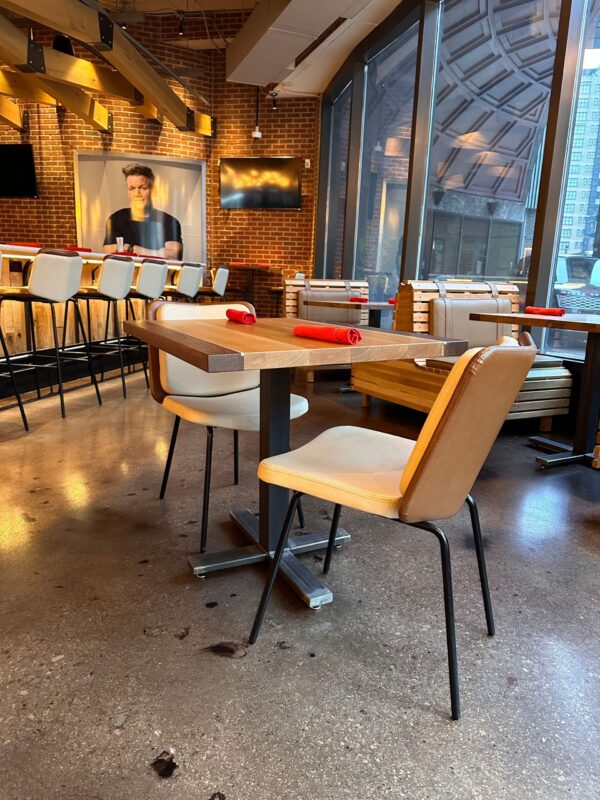 South Loft custom dining table and chairs with red napkins in a modern restaurant setting.