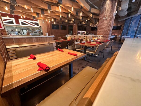 South Loft custom wooden booth and dining tables with red napkins in a modern restaurant interior.