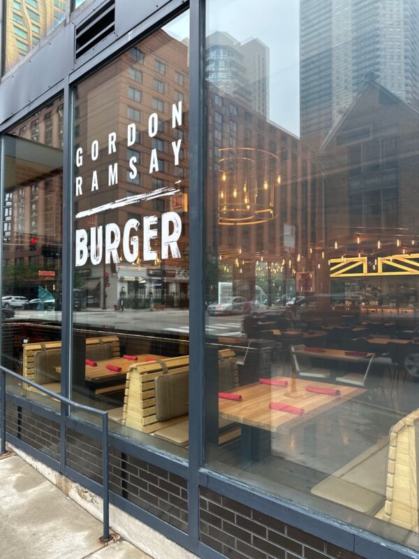 Exterior view of Gordon Ramsay Burger restaurant with South Loft custom booth seating visible through the window.