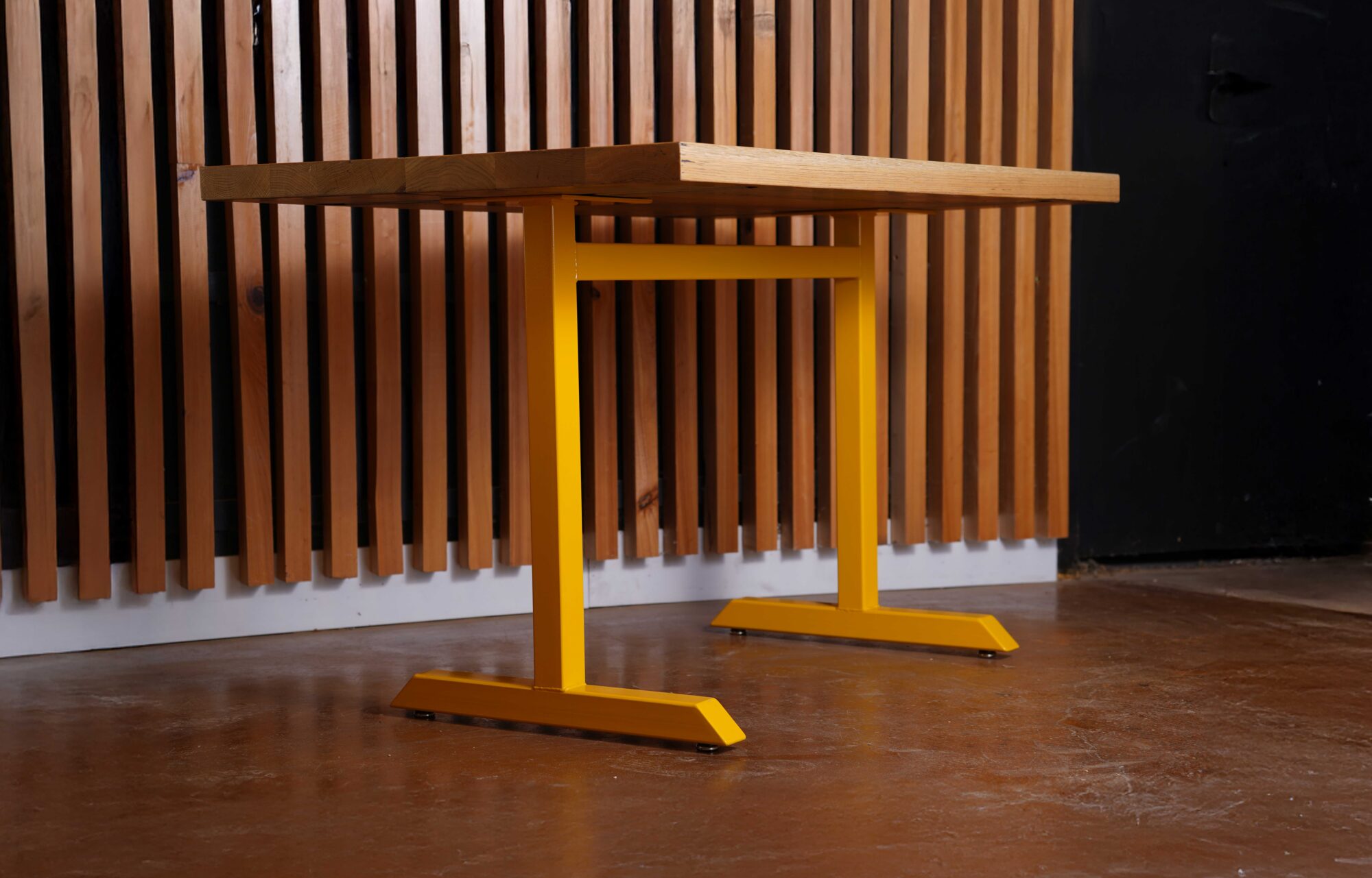 A 210 Series base from SL Commercial finished in a yellow powder coat sits in the the SouthLoft facility.