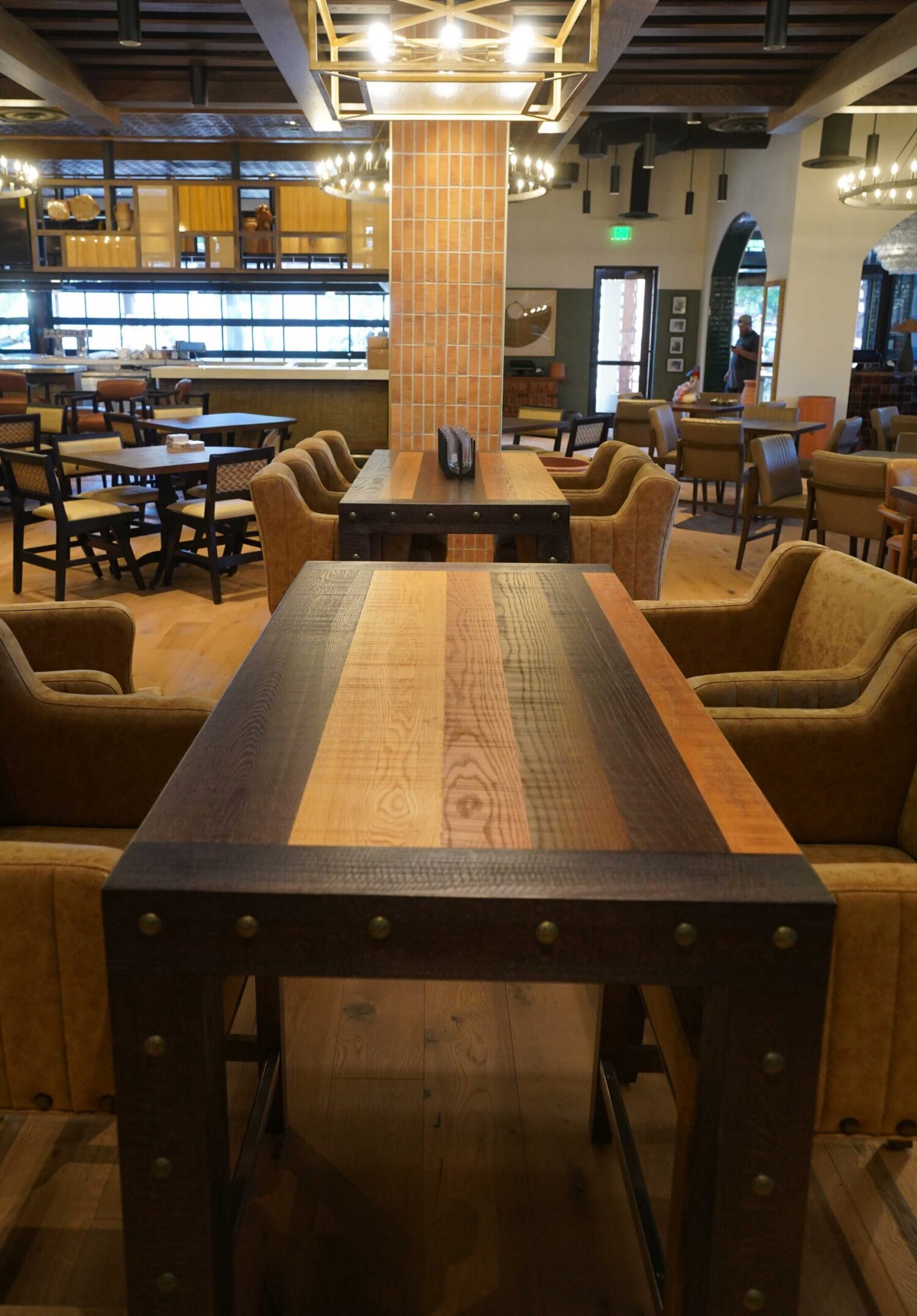 A mixed species communal dining table built by SouthLoft sits in a large dining room.