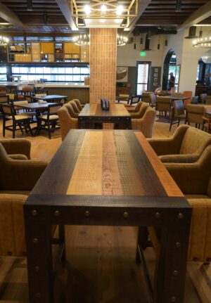 A mixed species communal dining table built by SouthLoft sits in a large dining room.