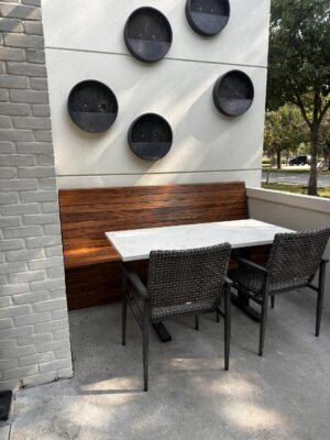 A wooden booth flanks a table and chairs at a Mexican Sugar location.