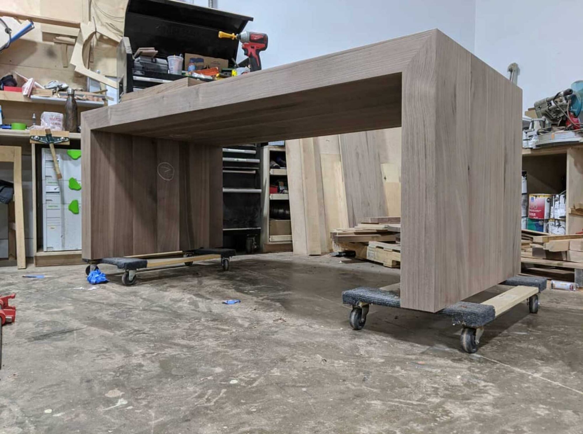 130 Series waterfall table being built in SouthLoft's production facility. The table does not yet have finish applied and rests on furniture dollies.