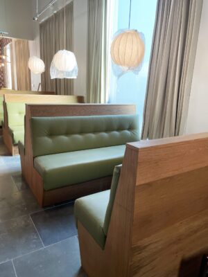 A row of SouthLoft made dining booths with custom upholstery match this spacious and well lit dining space.