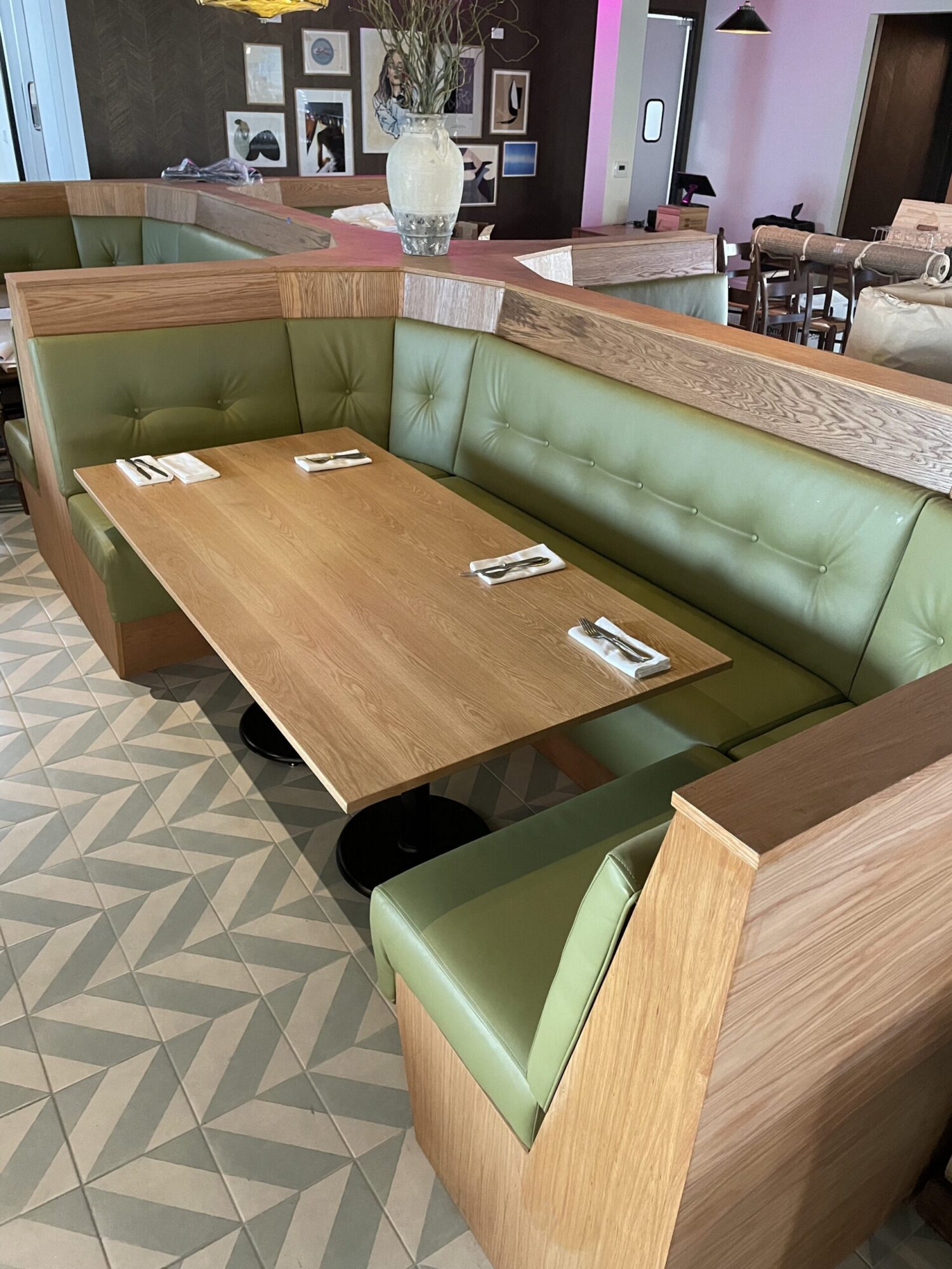 A SouthLoft made table and surround booth with custom upholstery sits in a dining space with a funky patterned floor