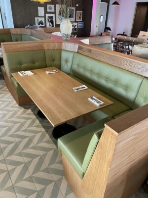 A SouthLoft made table and surround booth with custom upholstery sits in a dining space with a funky patterned floor